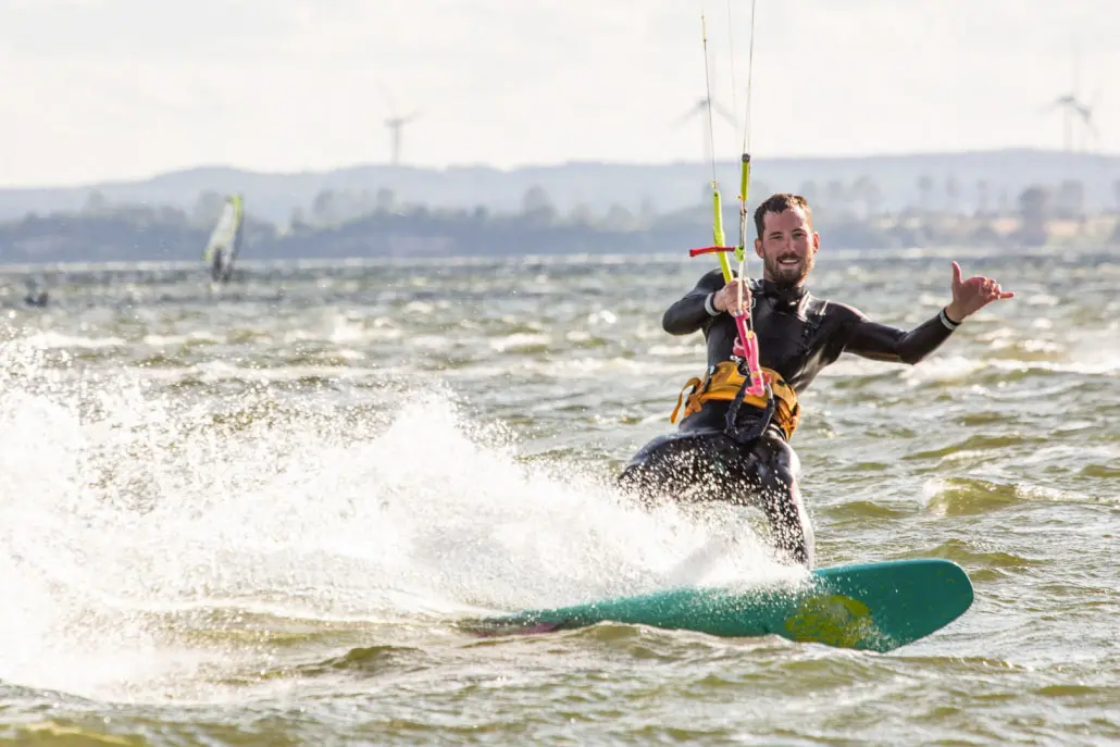 Kitesurfer na desce podczas kursu w Chałupach.
